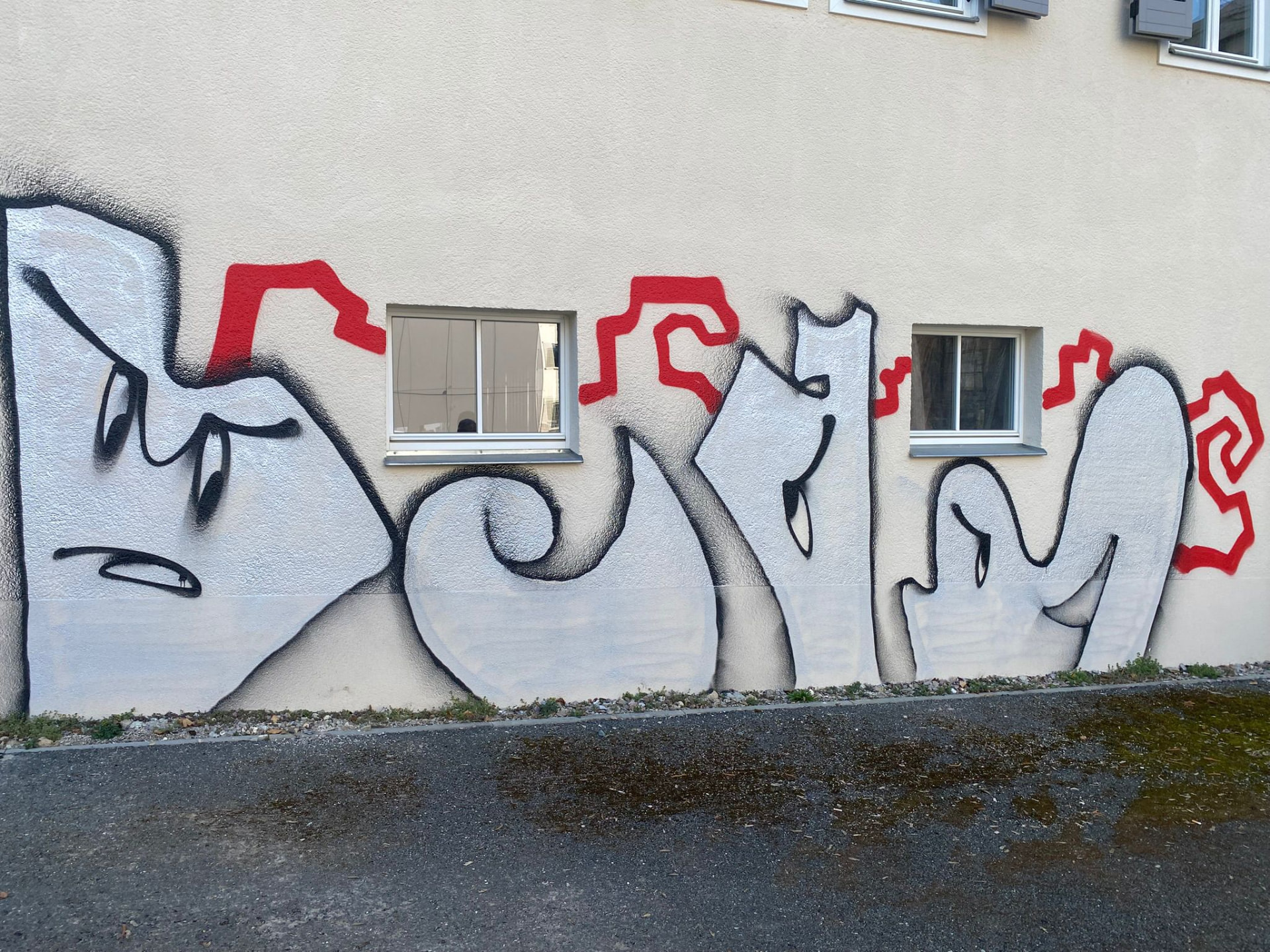 Putzfassade mit großem Graffiti vor der Reinigung
