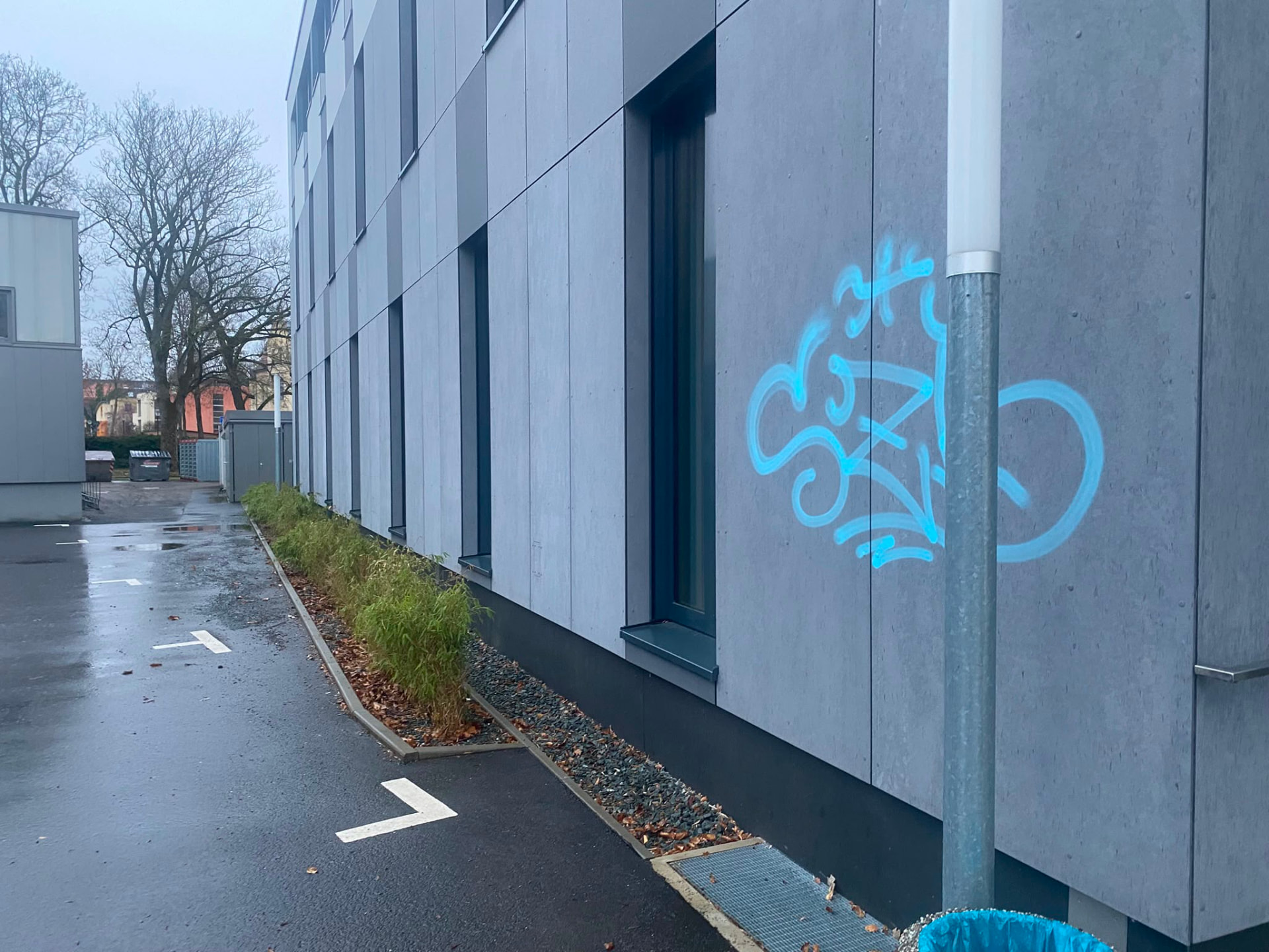 Fassadenplatten mit blauem Graffiti-Tag vor der Reinigung